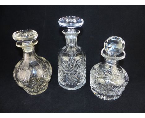 A cut glass mallet form decanter with mushroom stopper and two squat form cut glass decanters and stoppers. (3)