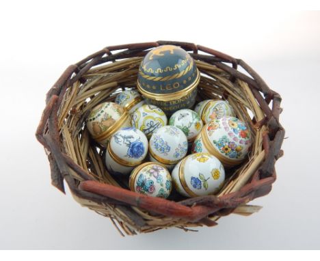 Collection of eleven Halcyon days and similar ceramic eggs, within a nest basket, (12) 