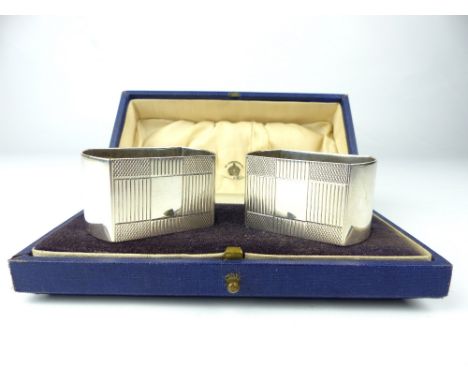 Pair of cased Mappin & Webb Art Deco silver napkin rings, engine turned design, vacant cartouche, Birmingham, 1938.