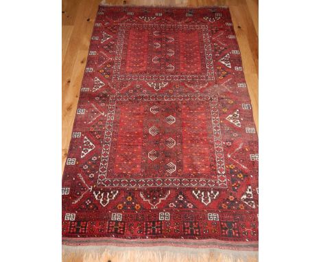 Persian Turkoman red ground carpet with two geometric panels within a wide border, 250 x 158cm.