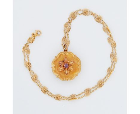 A yellow gold Georgian flower &amp; scroll design locket set with a central oval cut ruby and on the reverse a letter, diamet