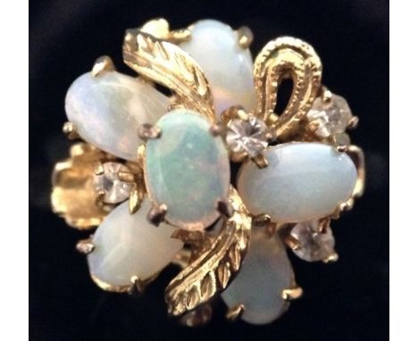An opal and white stone flower head cluster ring, the multi-level crown set with six cabochon opal doublets, and four white p
