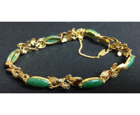 A 14ct gold and jade articulated bracelet, six oval jade panels interspaced with floral links, stamped 14k, 18cm long, 12.8g 