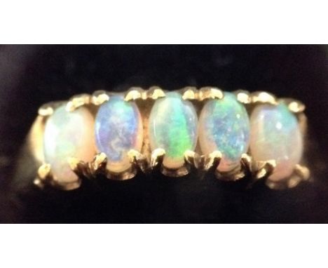 An Edwardian style five stone opal ring, five uniform oval opal doublet cabochons, each with green, blue and fire orange colo