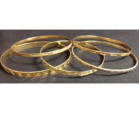 A yellow gold hoop bangle, bright cut decoration, stamped 750; another, similar, stamped 750, (18g);  a pair of 9ct gold hoop
