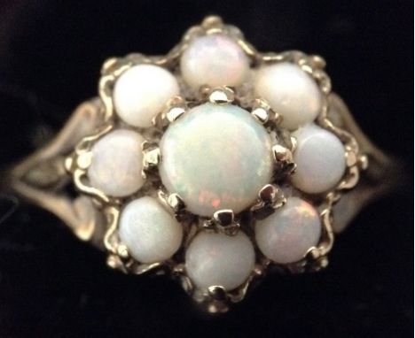 A Victorian style opal flower head cluster ring, central round opal surrounded by eight smaller opals, 9ct gold shank, size L