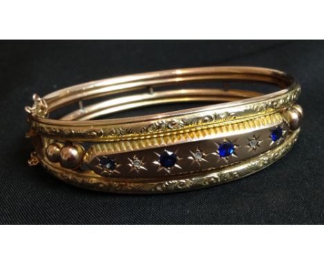 An Edwardian sapphire and diamond hinge bangle, seven stone oval panel alternate set with four blue sapphires and three old c