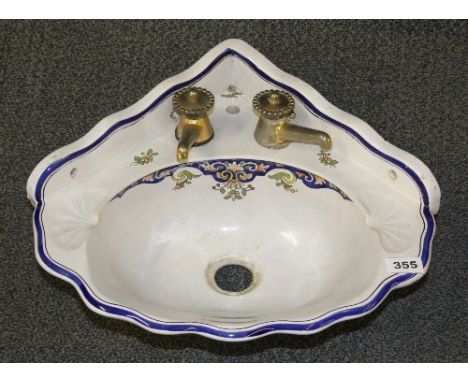 A hand painted Faience corner wash basin with brass taps W 47cm