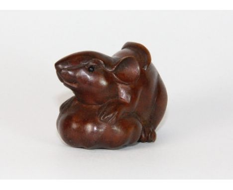 A carved wooden mouse netsuke with black onyx eyes