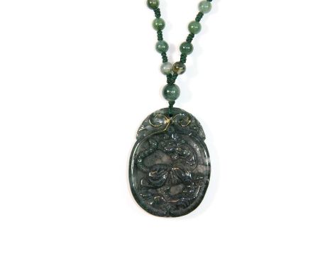 A spinach jade carved tiger amulet on a spinach jade beaded necklace