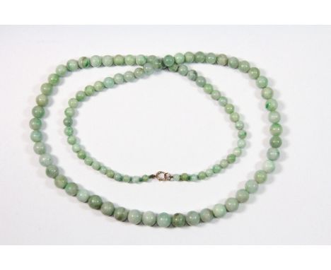 An old graduated Chinese green jade necklace on a 9ct gold clasp L 68cm