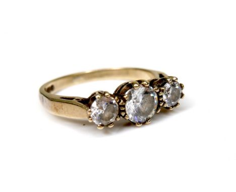 A 9ct gold and three white stone ring, the central largest brilliant cut stone, 5.5 by 3.4mm, flanked by two smaller brillian