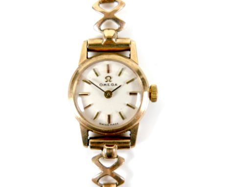 An Omega 9ct gold lady's wristwatch, circa 1965, model 511.5182, with circular champagne dial, gold baton numerals, black han