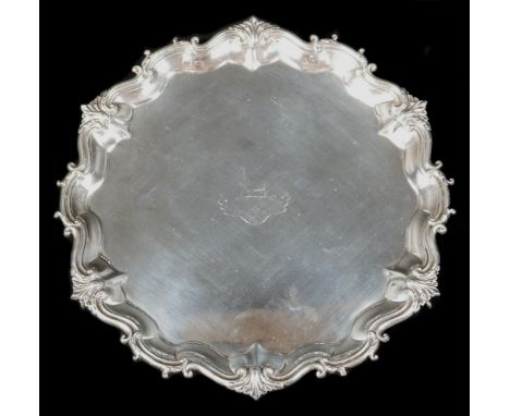 A Victorian silver tray, of shaped circular form with Chippendale pie crust edge, central engraved armorial crest, and raised