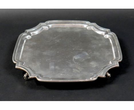 A silver tray, of square form with incuse corners, raised upon four scroll feet, 3 by 26.5cm, 21.7toz. 