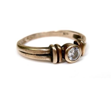 A 9ct gold and white stone solitaire ring, of modern design with double banded shoulders and central brilliant cut stone of a