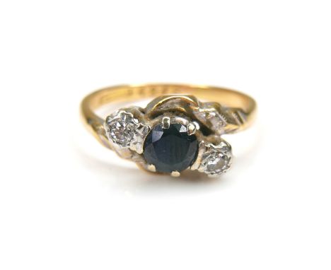 An 18ct gold and platinum mounted sapphire and diamond ring, the central round cut sapphire, 4.7mm diameter, with two round c