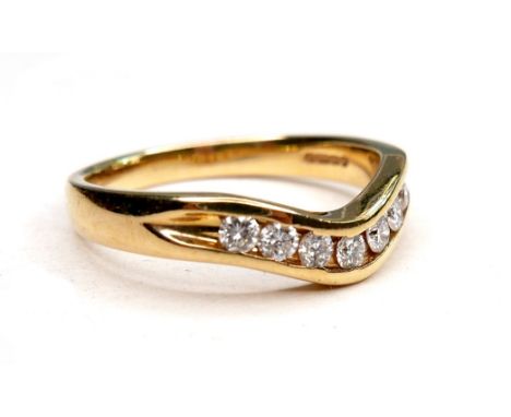 An 18ct gold and seven stone diamond ring, diamonds 1mm diameter, size Q/R, 5.2g. 