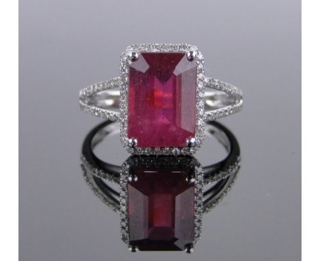 A 14ct white gold 4.67ct emerald-cut ruby and diamond ring,total diamond content approx. 0.5cts, setting height 12mm, size M.