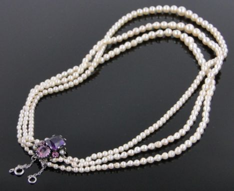 A graduated triple strand cultured pearl necklace,with gemstone set clasp by Dorrie Nossiter.