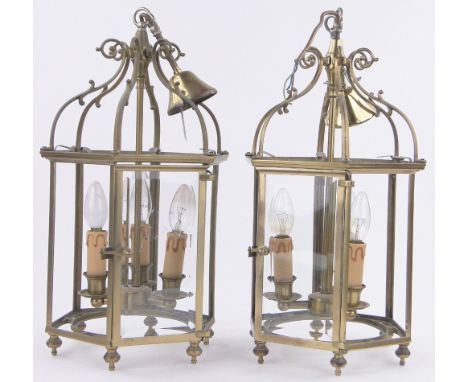 A pair of brass framed hexagonal lantern light fittings,with bevel glass panels, height to top of scrolls 47cm, diameter 26cm