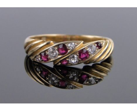 An 18ct gold ruby and diamond set band ring,size O.