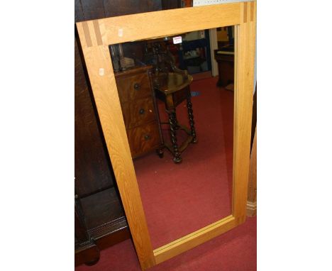 A contemporary light oak framed rectangular wall mirror, 131 x 70cm