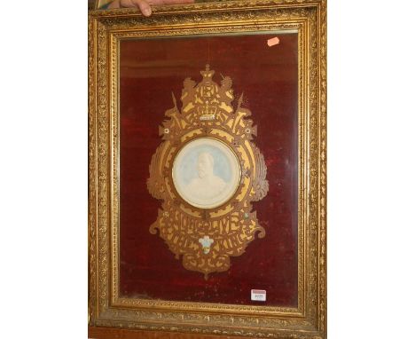 An Edwardian commemorative fret carved plaque inset with bisque portrait of Edward VII, the whole in glazed frame, full dimen