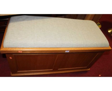 A contemporary light oak upholstered topped hinge top twin panel blanket box, width 94.5cm 