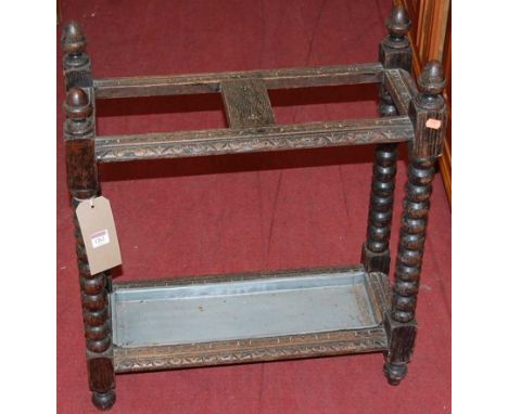 An early 20th century relief carved oak and bobbin turned twin division stick stand, width 61.5cm