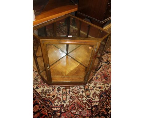 An early 20th century oak and polished brass mounted low corner retailers display cabinet, having single glazed and mirrored 