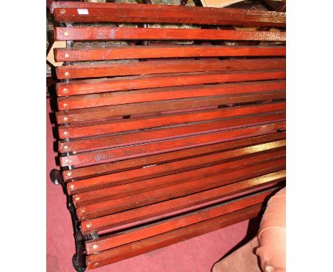 A black painted wrought iron framed and stained slatted pine three-seater garden bench, w.157cm