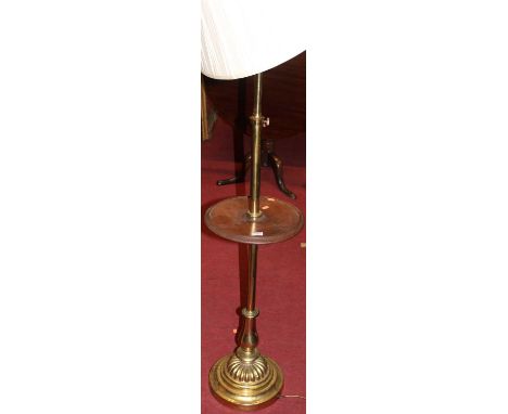 A polished brass telescopic standard lamp, with circular mahogany dished centre tier raised on circular stepped base, height 