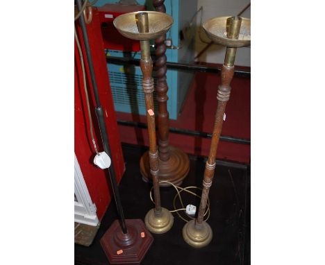 A 1930s barleytwist turned oak standard lamp; together with a pair of candle stands; and a contemporary brass standard lamp w
