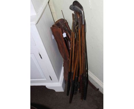 Vintage hickory shafted gold clubs and leather bag.