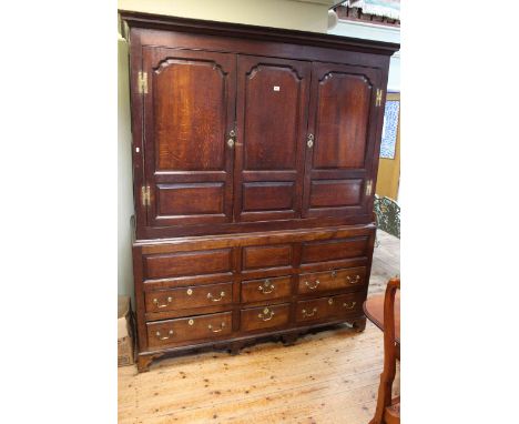 Georgian oak wardrobe having three arched fielded panel doors above four long and two short drawers, 204cm by 168cm by 58cm. 