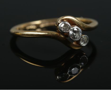 An 18ct gold three stone diamond ring. Central diamond approximately 0.125ct. Size M 1/2. 2.42g.