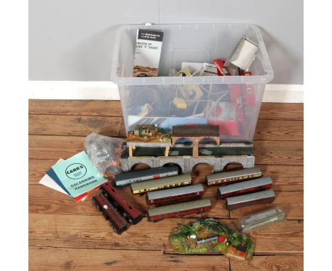 A large box containing model railway parts, accessories, train carriages, power controllers, handbooks and more, featuring br