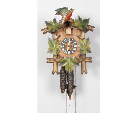 A German twin weight Black Forest Cuckoo clock with Regula movement and carved bird pediment over cuckoo window.