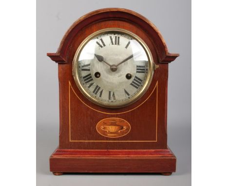 A mahogany and inlaid arched top Badische Uhrenfabrik mantle clock, with central urn patera. Featuring silvered dial and Roma