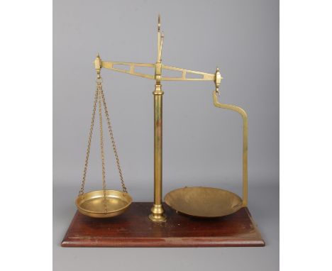 A set of brass balance scales on wooden base. The frame stamped for Parnall &amp; Sons, Bristol.