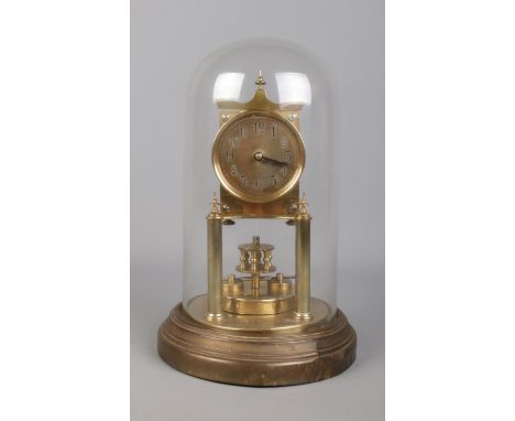 A brass based anniversary mantle clock under glass dome. The movement stamped for BHA, with the face bearing Arabic numeral m