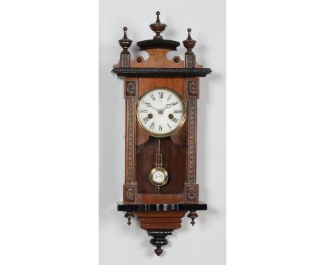 A mahogany cased Junghans wall clock of small proportions, featuring carved detailing to the door and frame and Roman Numeral