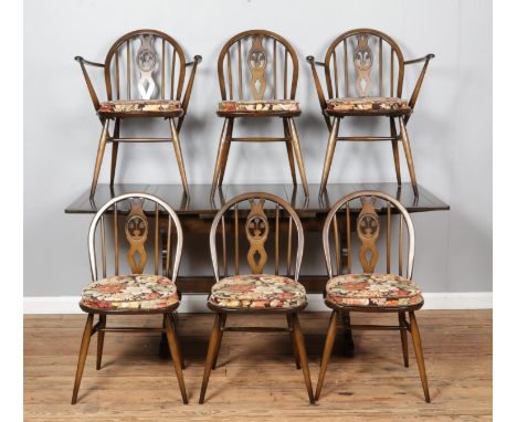 An Ercol Old Colonial draw-leaf table; Model 758, together with six Windsor 'fleur-de-lis' dining chairs; four Model 371 and 