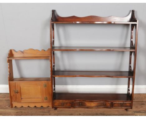 A mahogany wall hanging shelf with three integral drawers with a smaller pine example