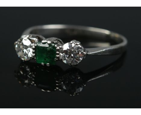 An Art Deco platinum emerald and diamond ring. Each diamond approximately 0.25ct. Size M. 2.56g.