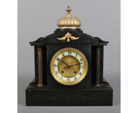A slate mantle clock, featuring reeded columns and central dome topped with brass finial. With Arabic Numeral dial and French