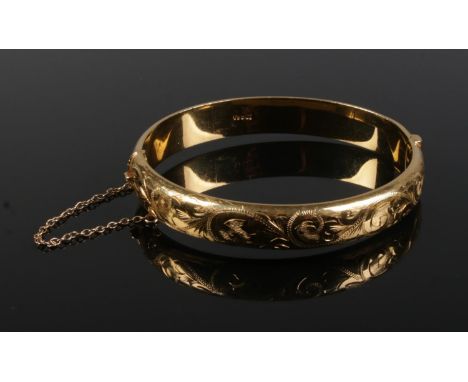 A one fifth 9ct gold bangle with engraved decoration. 16.83g.