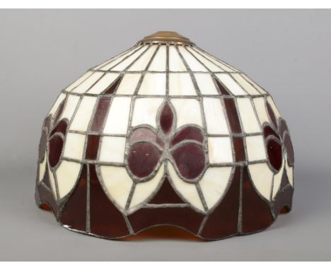 A Tiffany style lamp shade, with cream and deep red panels separated by lead lining. Diameter: 37cm.