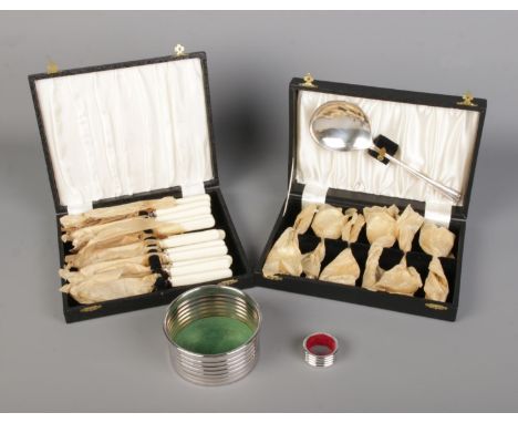 A collection of unused silver plated flatware, wine coaster and wine bottle drip ring.